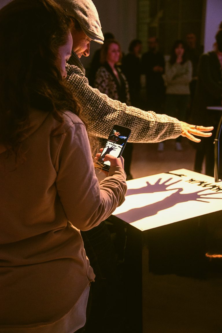 An adult and child participant create music together by casting shadows at Cave of Sounds, Music Hackspace, Somerset House Studios. Photo: Suzi Corker